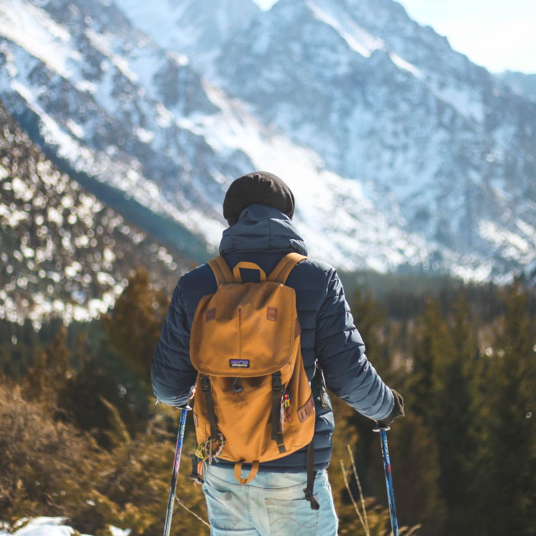 Mann auf Gipfel beim Winterwandern